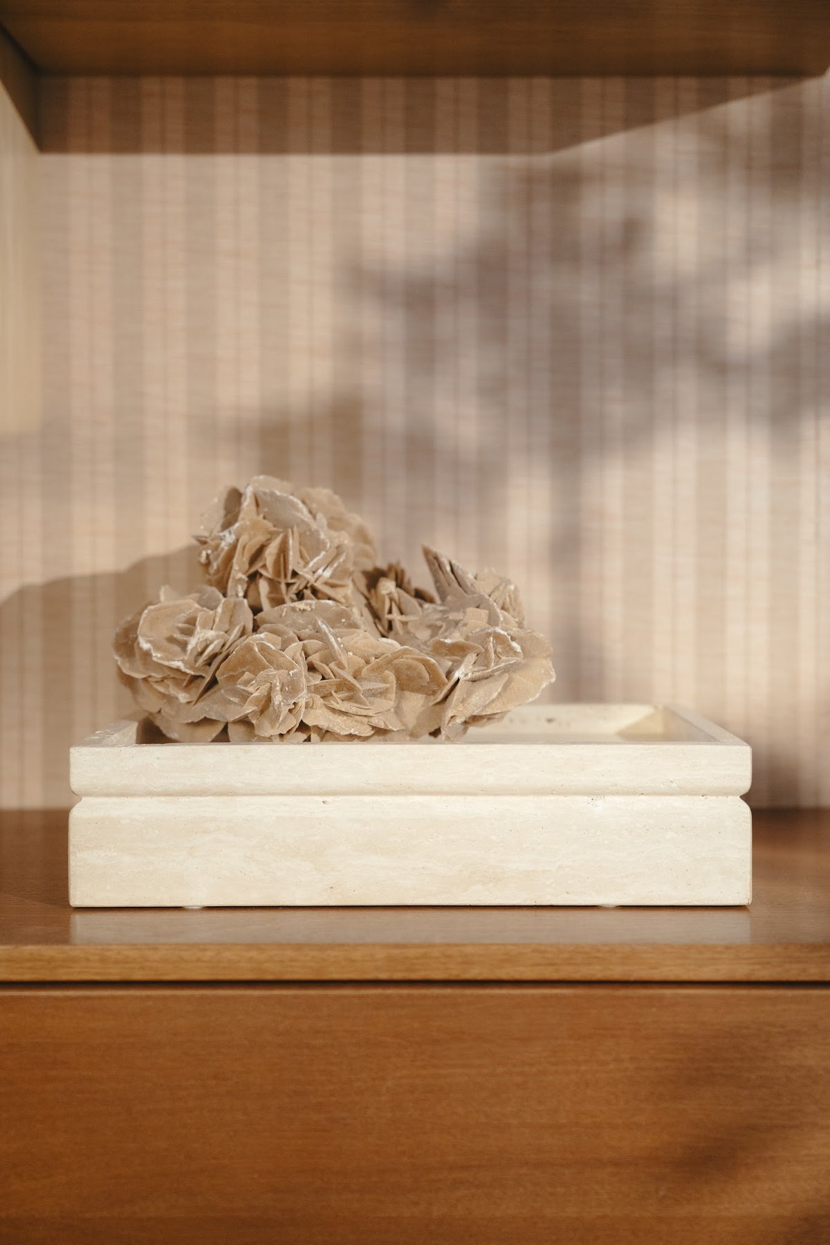Classic travertine Tray urn styled with coral on a wooden sideboard