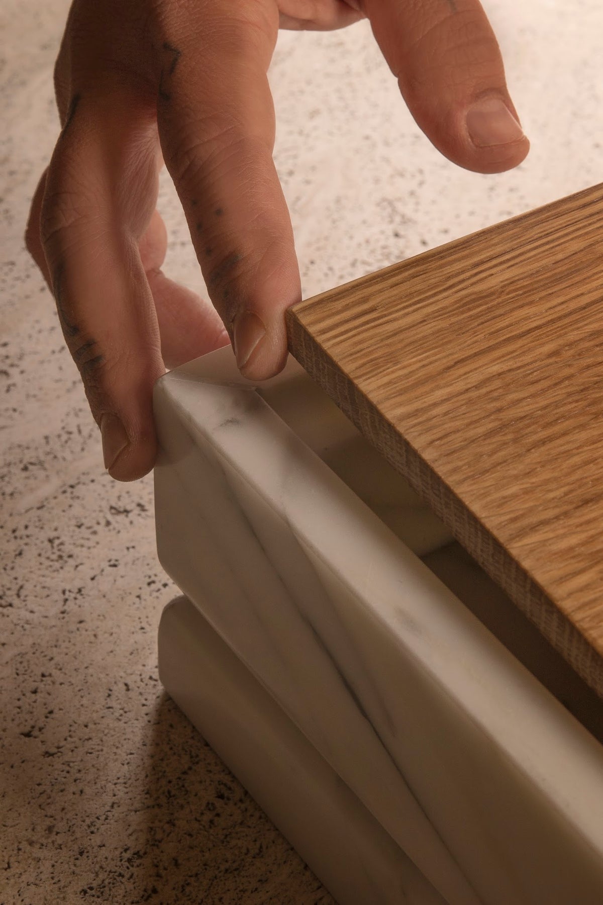 Hands lifting the oak lid of the Tray urn, revealing the concealed compartment